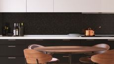 A kitchen with dark tiling, drawers, wooden furniture and a glass induction hob