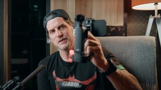 YouTuber Hugh Sweeney talking to the camera while holding a mini rig for the DJI Osmo Pocket 3