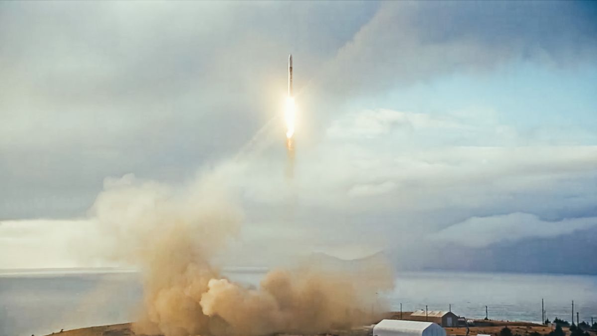 long-distance shot of a rocket launching into a cloudy daytime sky