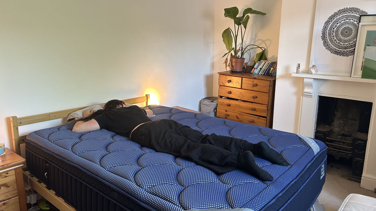 Our mattress tester assessing the comfort and support of the DreamCloud Luxe Memory Foam mattress by lying on her stomach