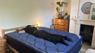 Our mattress tester assessing the comfort and support of the DreamCloud Luxe Memory Foam mattress by lying on her stomach