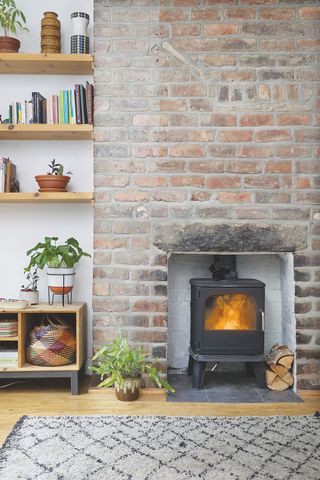 brick fireplace with woodburning stove and shelving around alcove