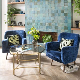 blue tiled chimney breast with blue archers and gold and glass coffee table