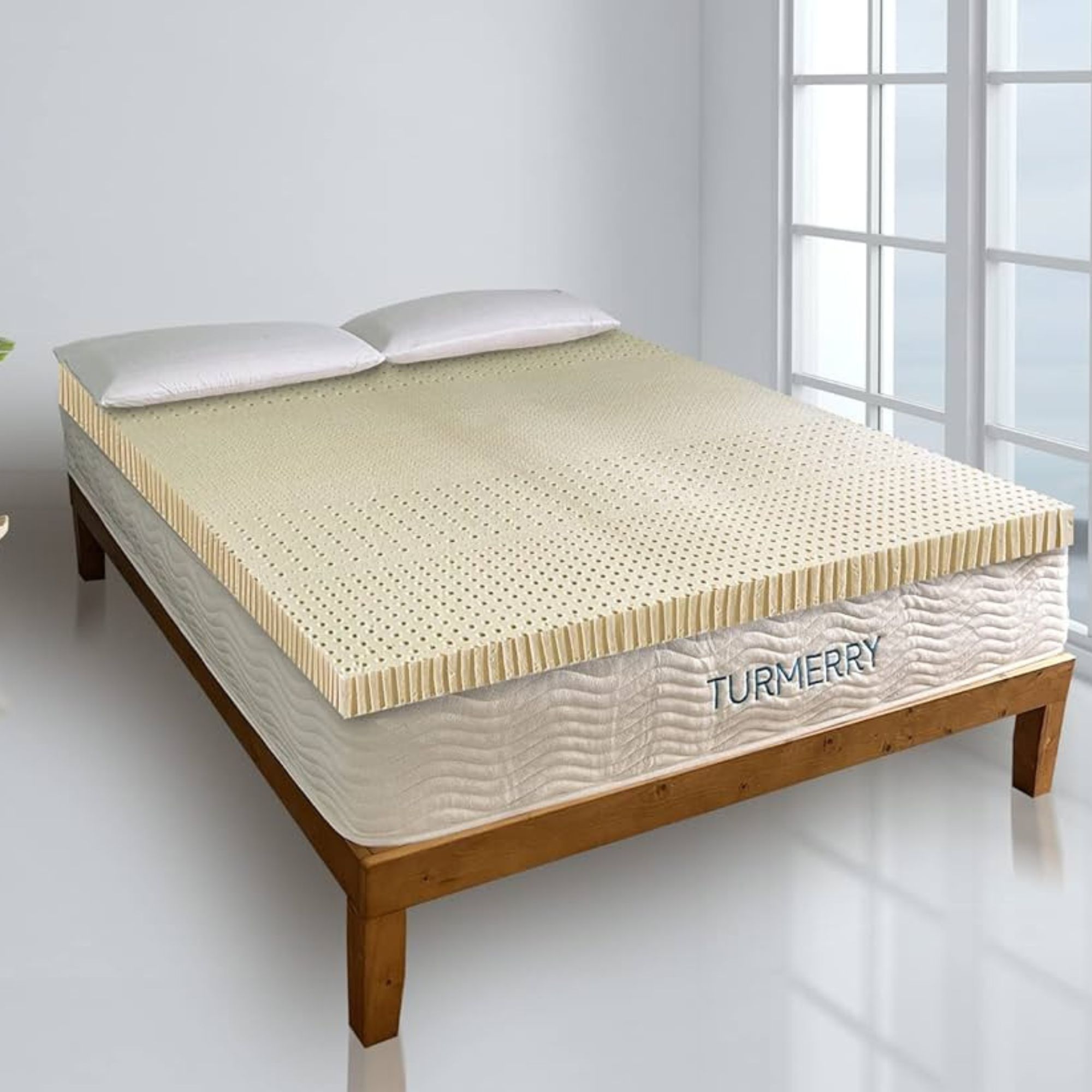 Turmerry Latex Mattress Topper on a bed against a white wall.