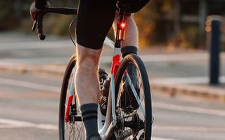 The MagicShine SEEMEE R300 rear radar light mounted on a road bike with rider
