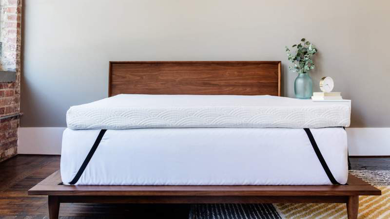 The Viscosoft active cooling copper topper shown on a wooden bed frame