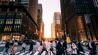 Office workers crossing a busy street in a Japanese city