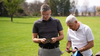 Golfers marking cards