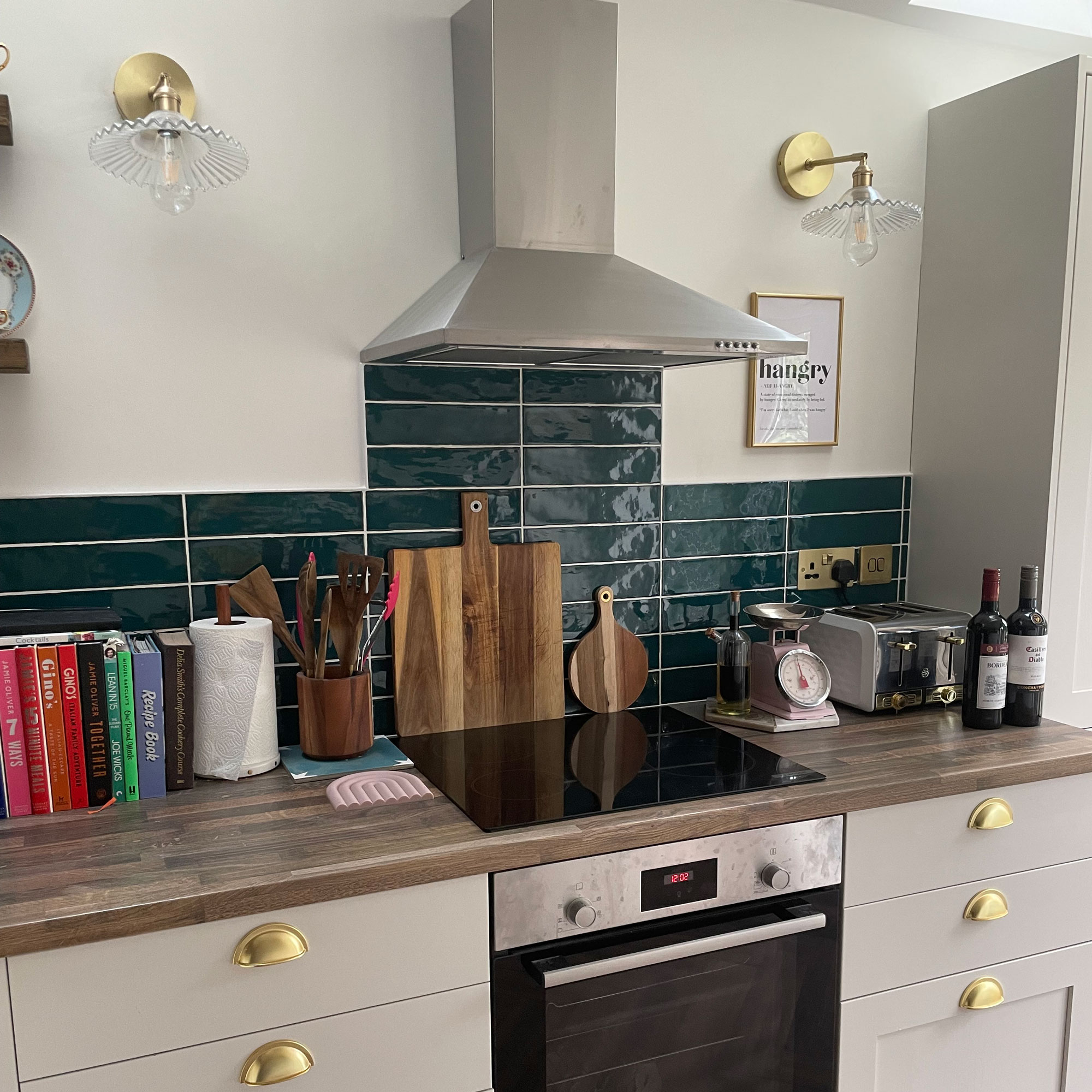 Cream kitchen with wooden worktops and green splashback