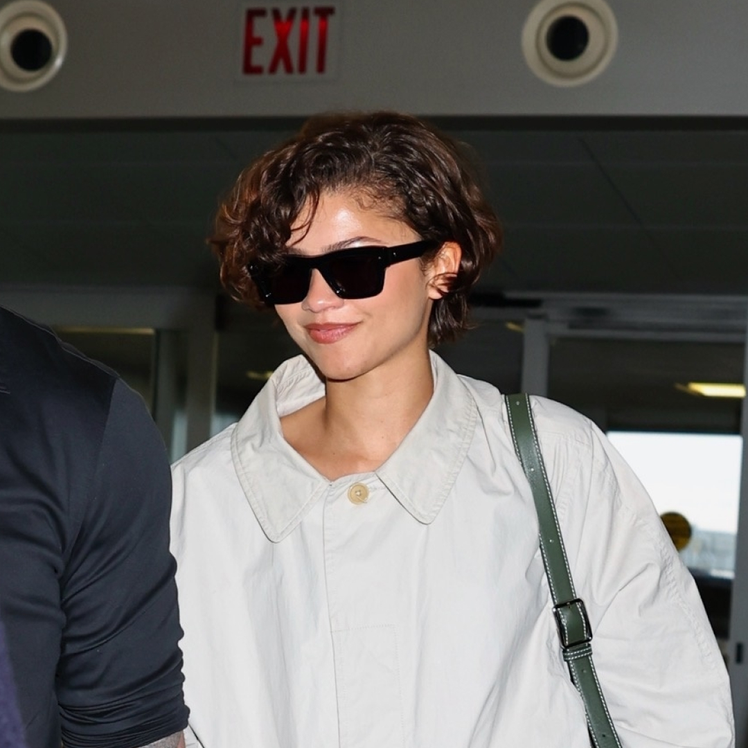 Zendaya heads to the airport in a white The Row trench coat, a white skirt, and black loafers, tapping into two Spring 2026 It-Girl trends
