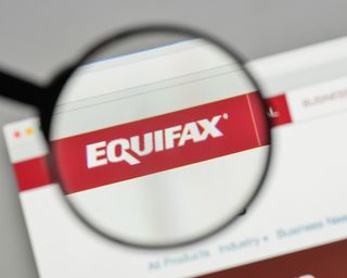 The Equifax logo being viewed under a magnifying glass