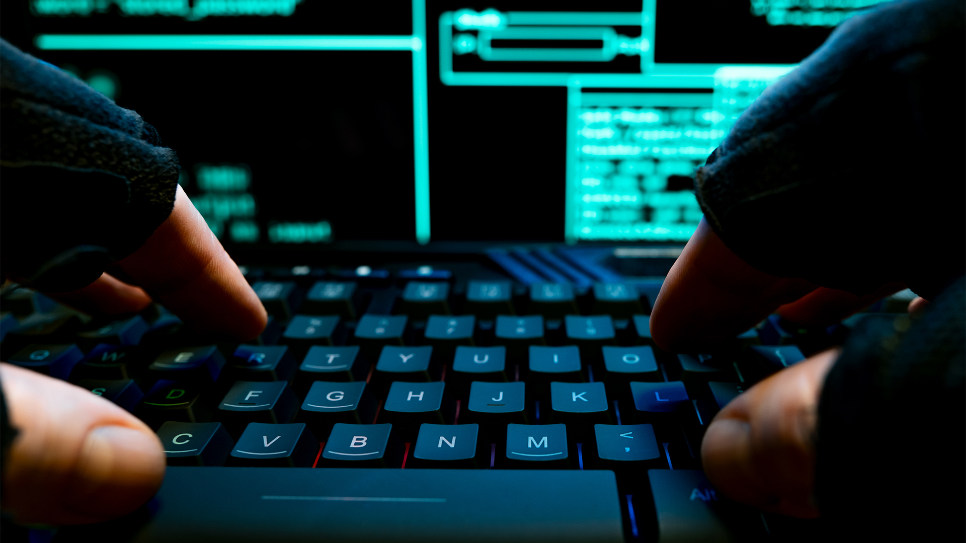 Insider attack concept image showing fingers typing on a keyboard with network systems panel pictured on monitor.