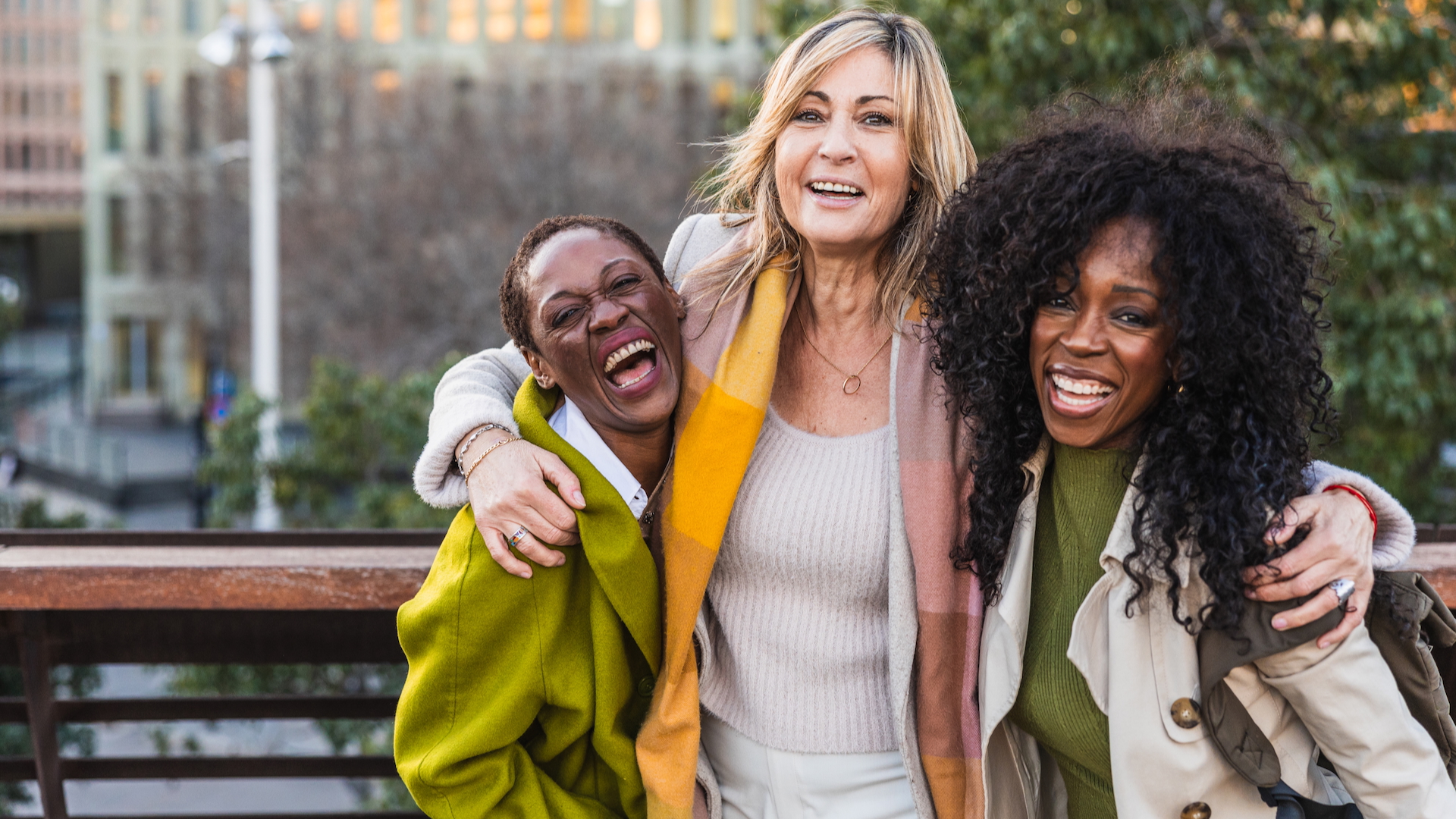A group of three women smiling and laughing together