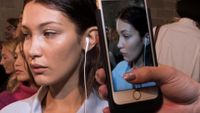 Bella Hadid wearing wired headphones 