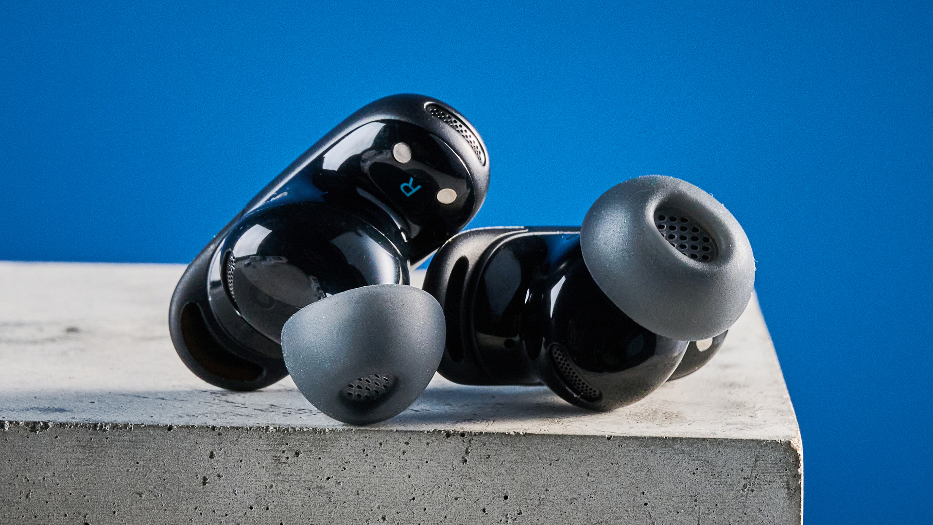 the soundcore liberty 5 pro max earbuds photographed against a blue tom's guide background