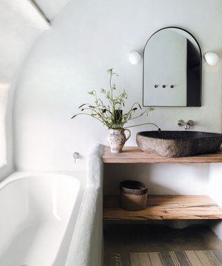 White bathroom, wooden shelves, black framed mirror
