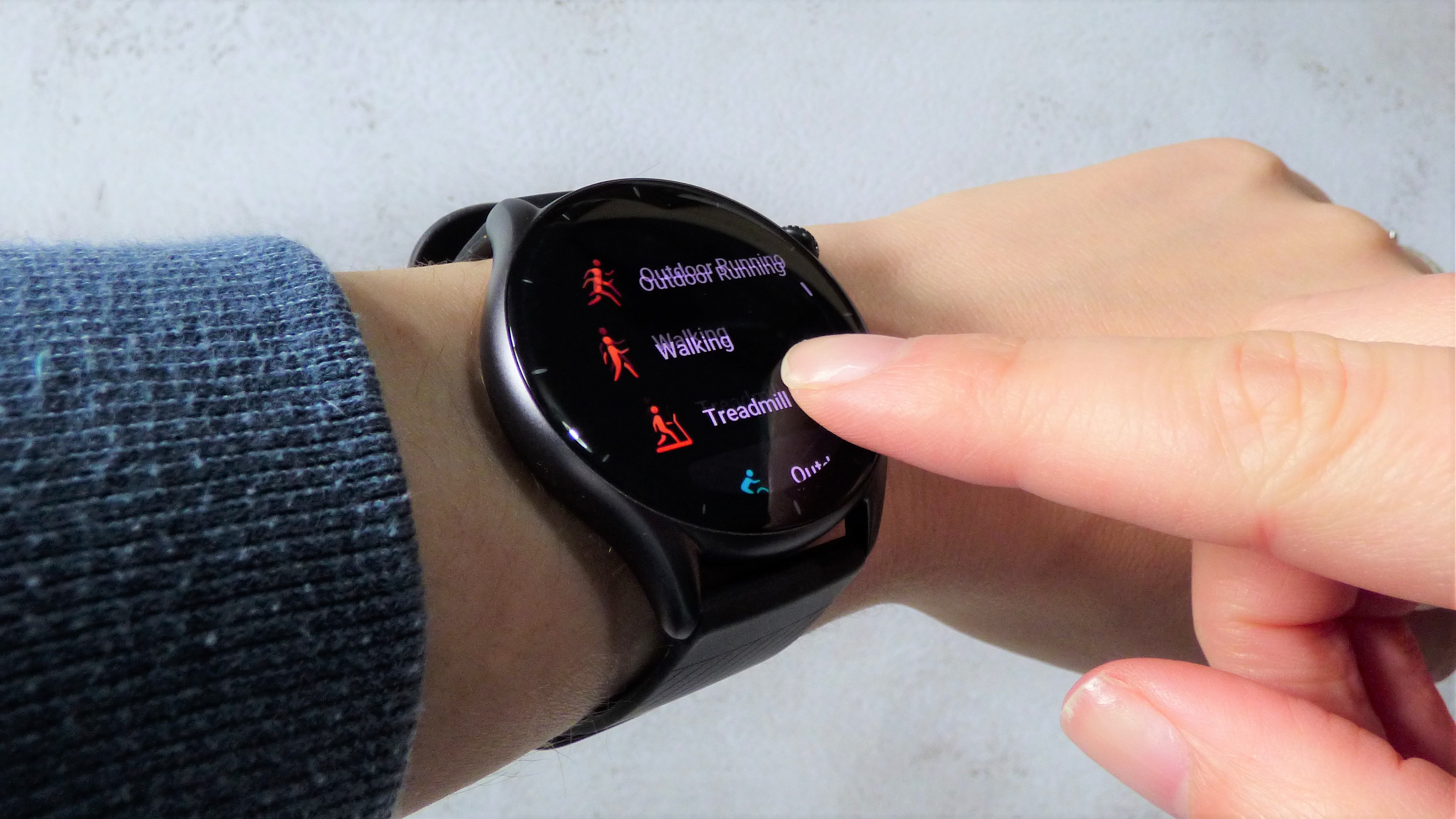 Woman scrolling through fitness tracking modes on Amazfit GTR 3 watch