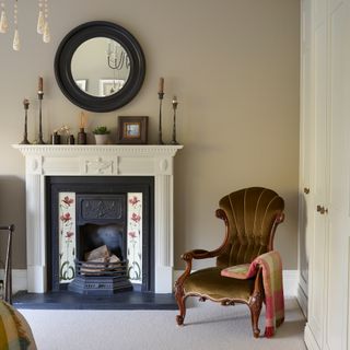 victorian reclaimed fireplace with floral tiled insert and velvet antique chair alongside