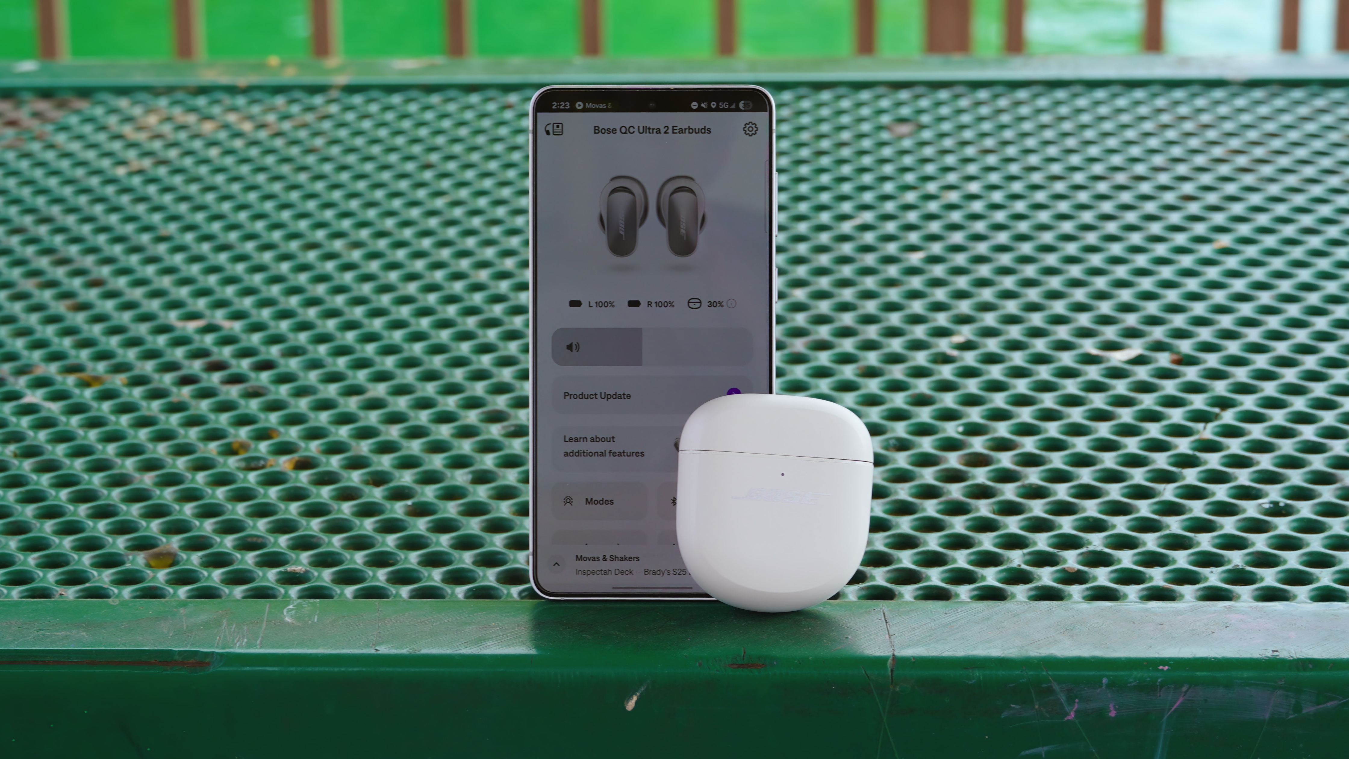 The Bose QuietComfort Ultra Gen 2 earbuds in their case beside a phone with the Bose app open.