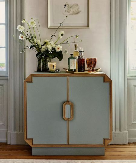 Blue and wood drinks cabinet, decorated with flowers and drinksware