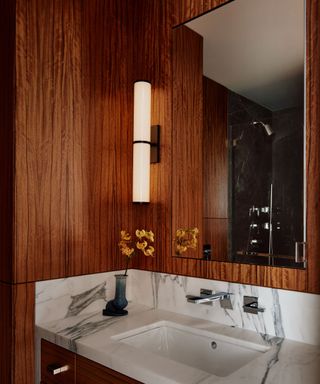 A bathroom with dark wood paneled walls