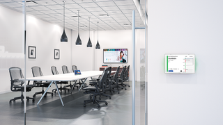 An empty conference room with the new Extron scheduling panels outside the door.