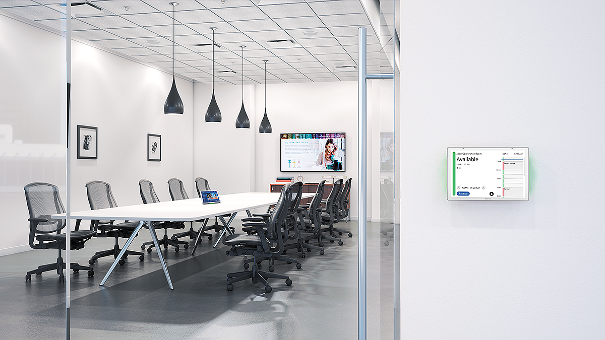 An empty conference room with the new Extron scheduling panels outside the door. 