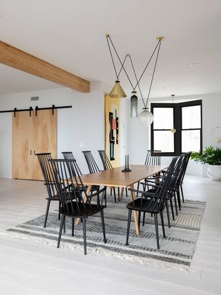 Dining room with oak table and black chairs with pendant lights above it
