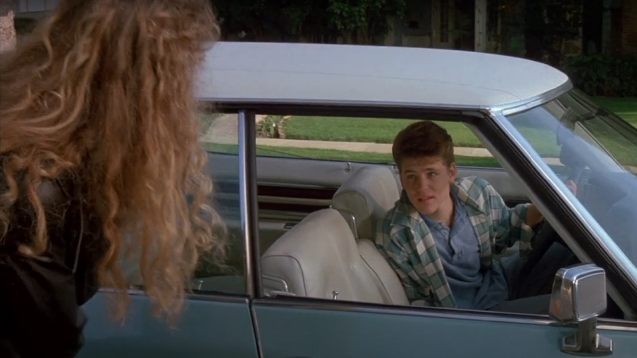 Corey Haim in a car asking out heatehr graham on the sidewalk in License to Drive