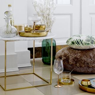 a marble top coffee table with gold frame with gold coffee table decor in a living room