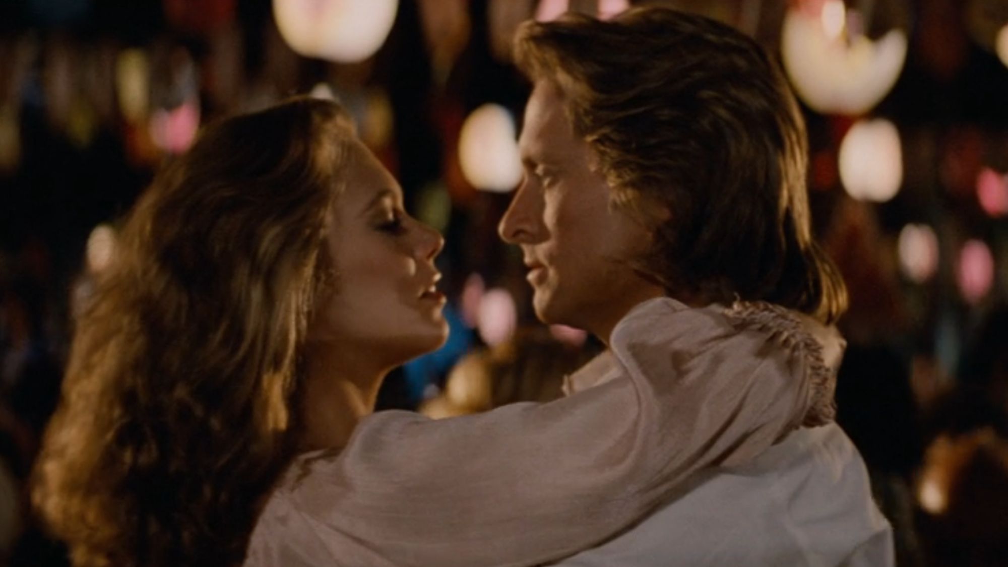 Joan Wilder (Kathleen Turner) and Jack T. Colton (Michael Douglas) prepare to share a kiss after dancing in Romancing the Stone.