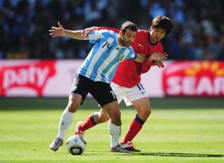 Argentina midfielder Javier Mascherano holds off South Korea's Ki Sung-Yueng in a game at the 2010 World Cup.