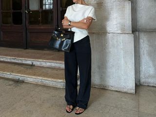 @deborabrosa outfit photo in white top, black pants, and flat sandals