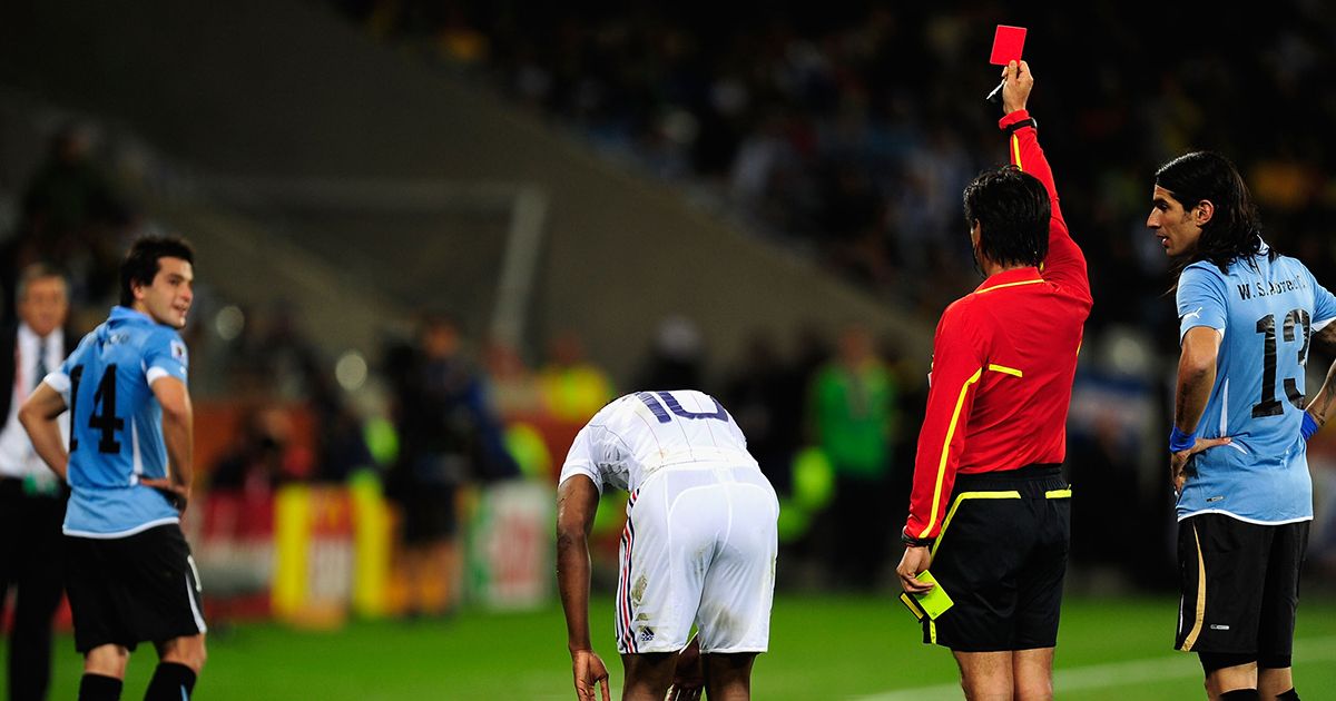 Nicolas Lodeiro of Uruguay (L) is shown a red card by Referee Yuichi Nishimura during the 2010 FIFA World Cup South Africa Group A match between Uruguay and France at Green Point Stadium on June 11, 2010 in Cape Town, South Africa.