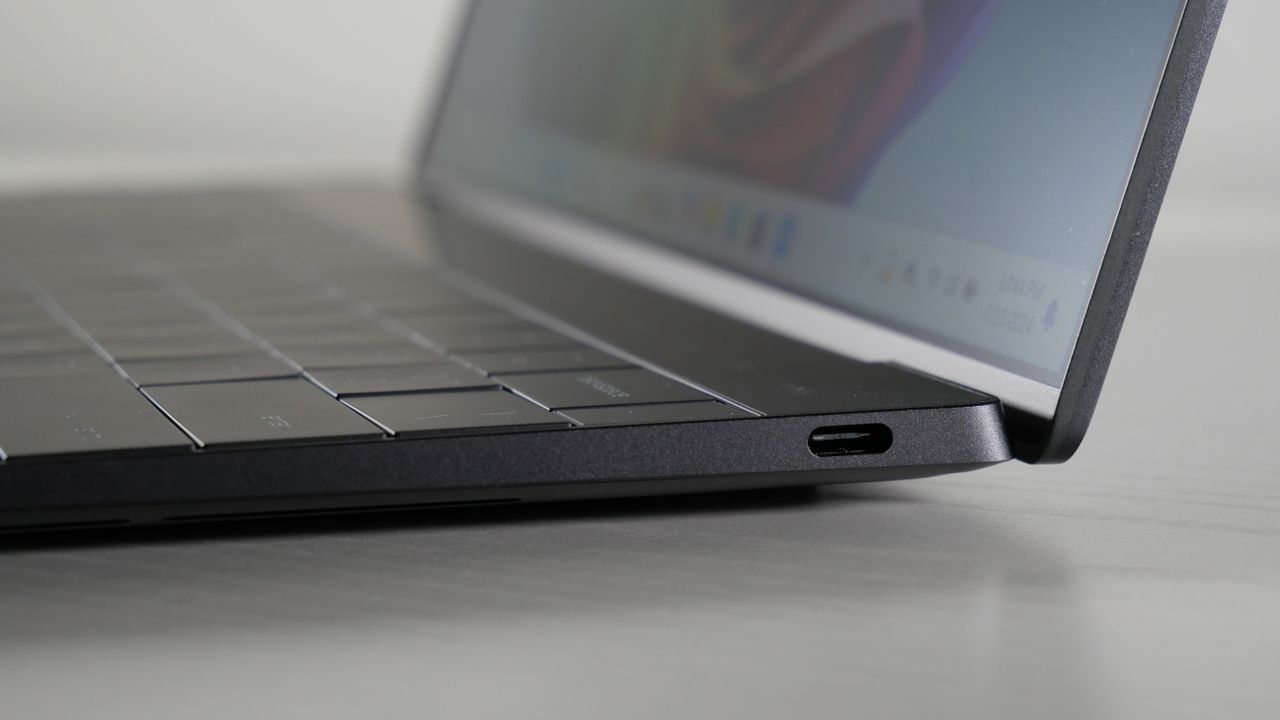 Close up of the USB-C port on the right side of a Dell XPS 13 9345 (Snapdragon X Elite) on a white table.