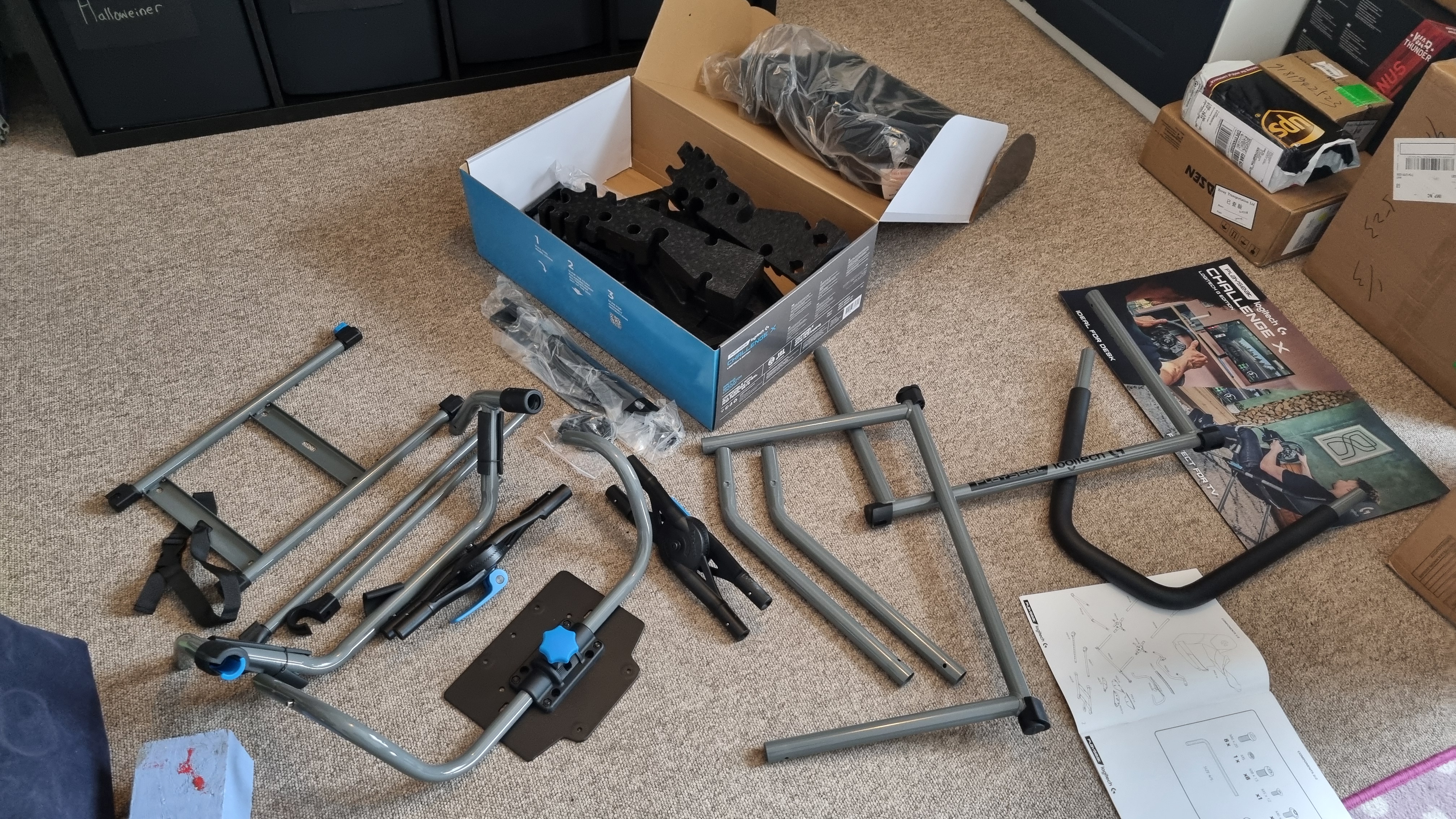 The parts for the Logitech Playseat Challenge X, spread out on the floor and disassembled