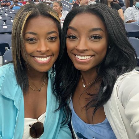 adria biles and simone biles embracing one another