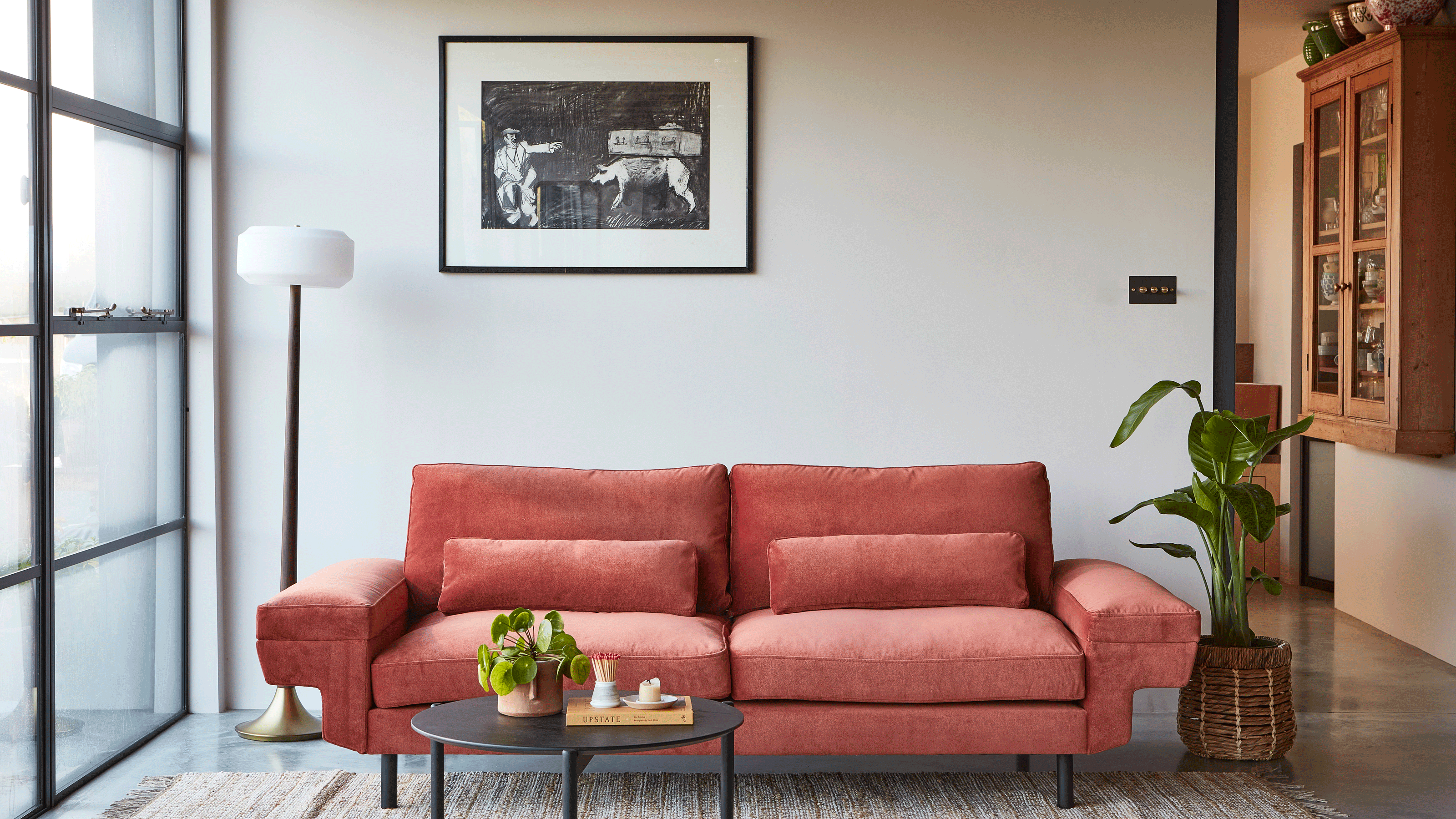 Red sofa in white room with black table and black photo frame
