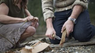 best camping knife: camping couple cutting wood