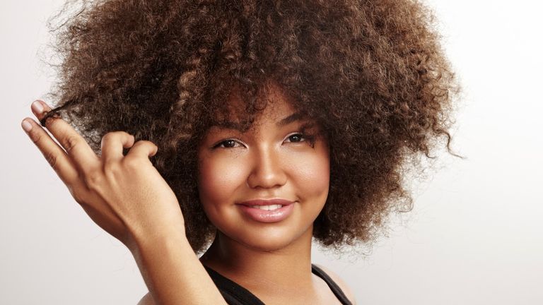 Portrait of young woman with afro hair - stock photo