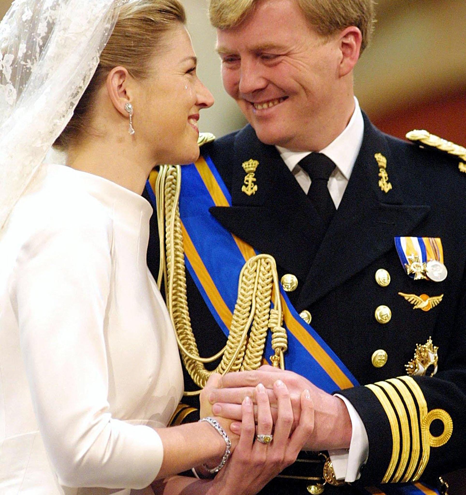 Queen Maxima and King Willem-Alexander holding hands and smiling on their 2002 wedding day