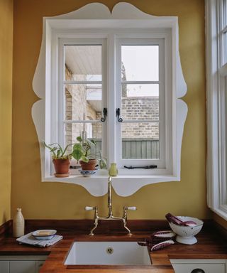 yellow wall painted with white decorative detail above sink