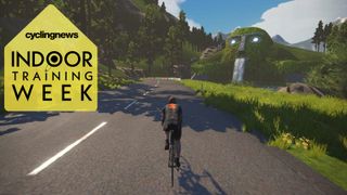 Zwift avatar rides past a hillside with a face carved into the side, with a waterfall coming from its mouth