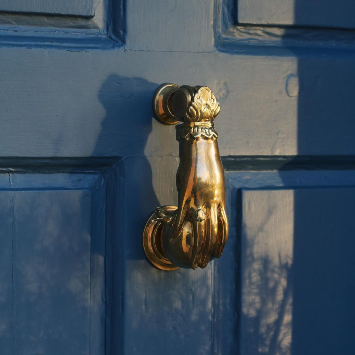 A brass door knocker in the shape of a hand