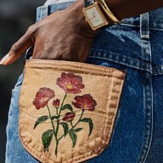 Woman putting her hand into her denim pocket