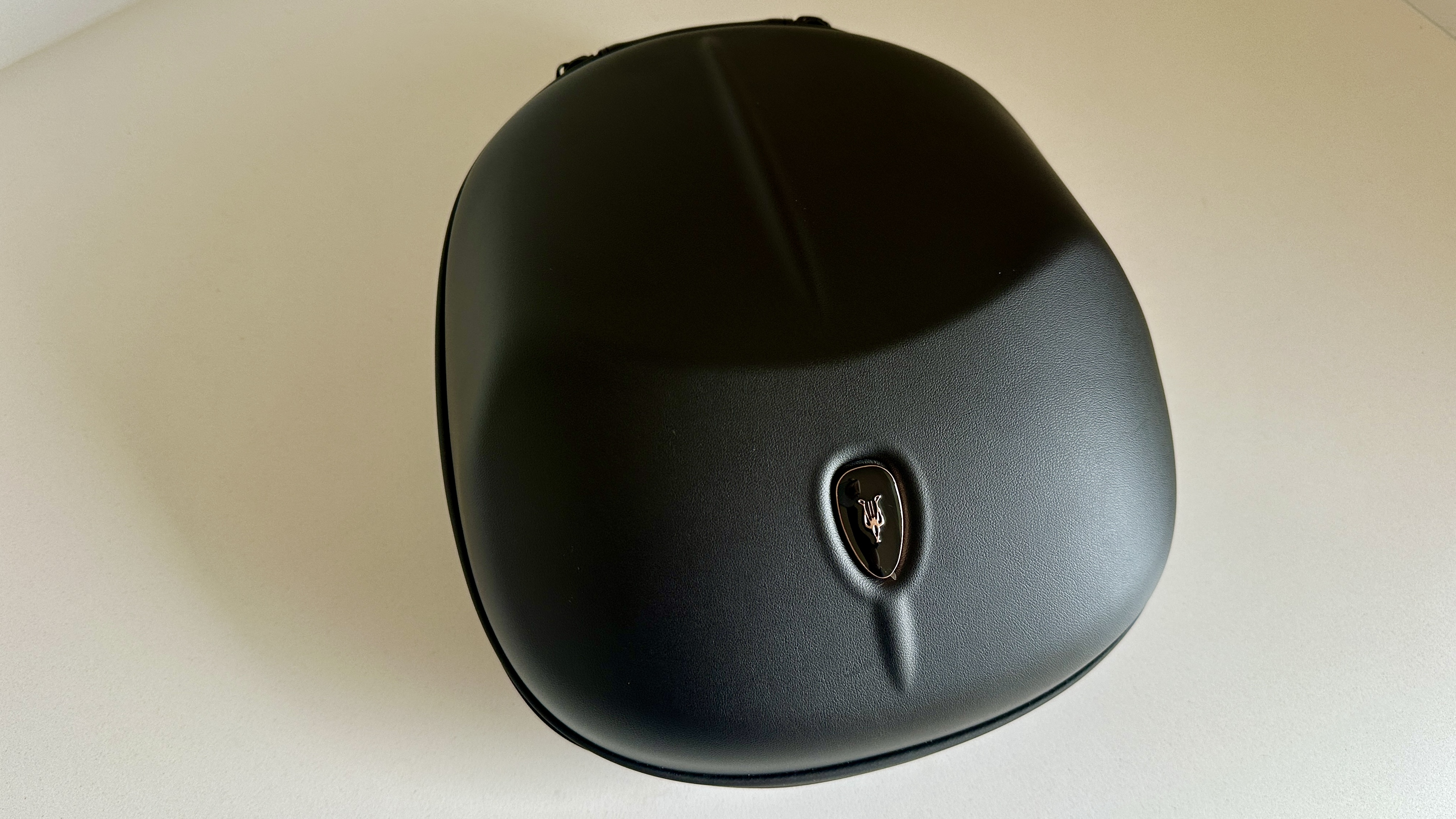 Meze Audio Strada headphones with wooden ear cups, in close-up and with their case and cables visible, on a white table