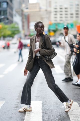 woman wearing adidas sambas, a blazer, a tank top, and jeans