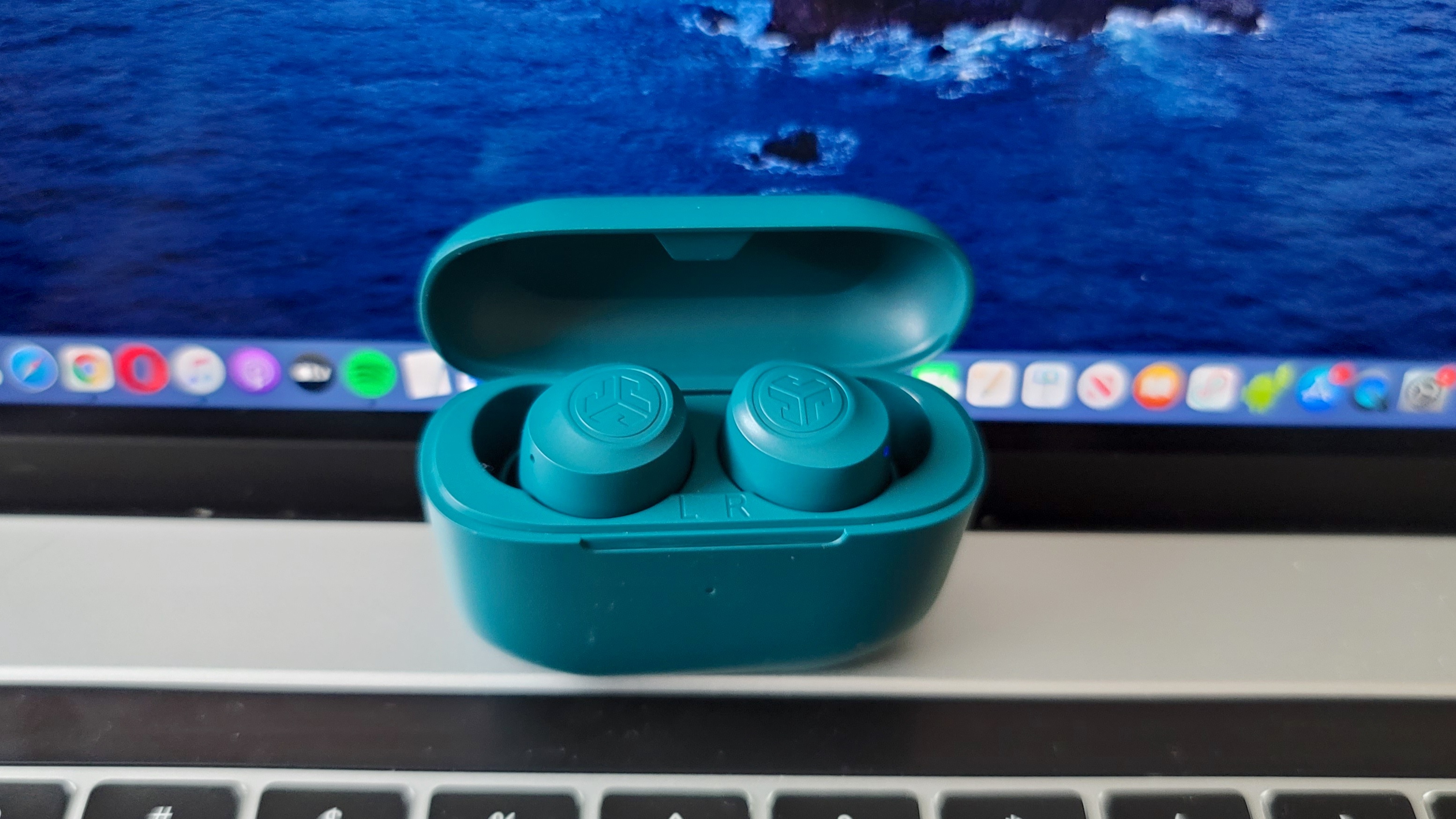 The JLab Go Air Pop placed in front of a MacBook Pro screen