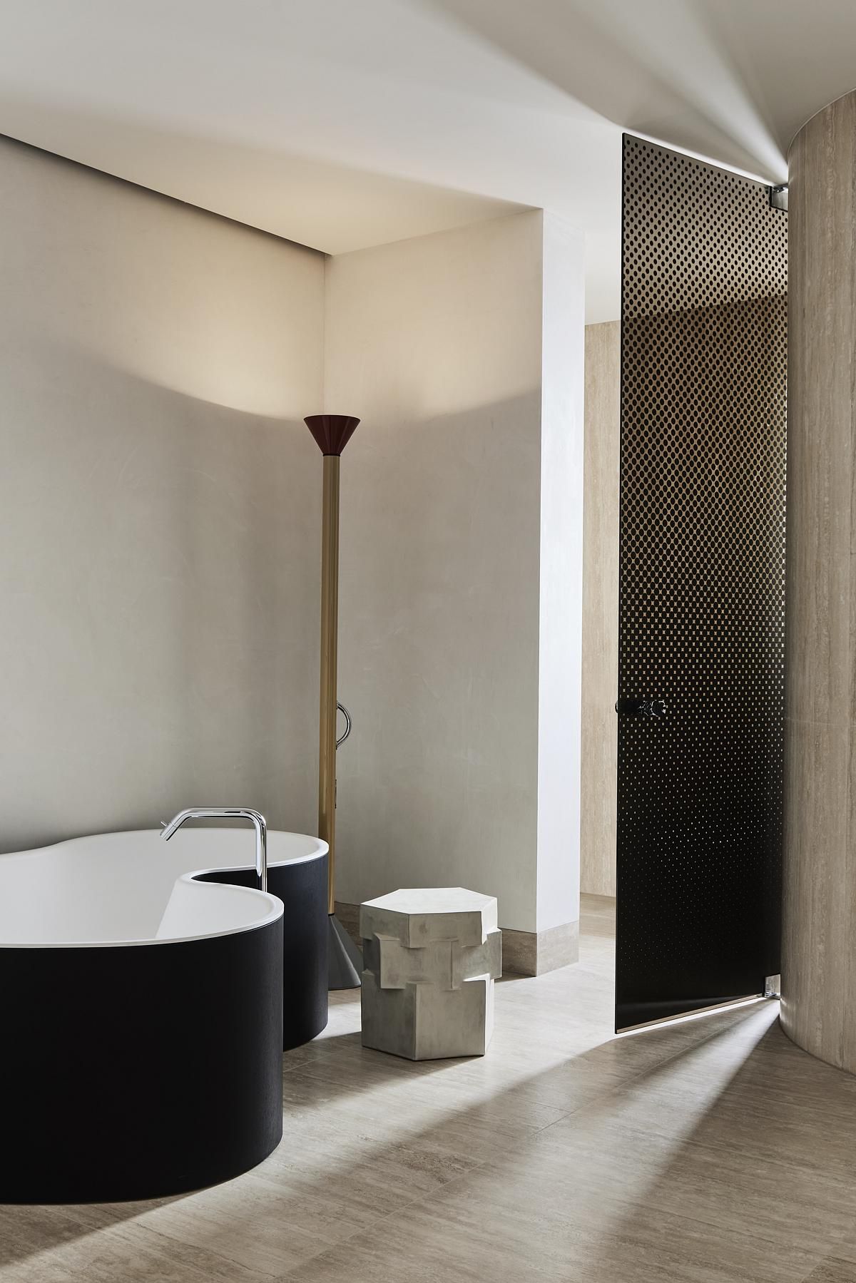 A bedroom with a tall uplight lamp