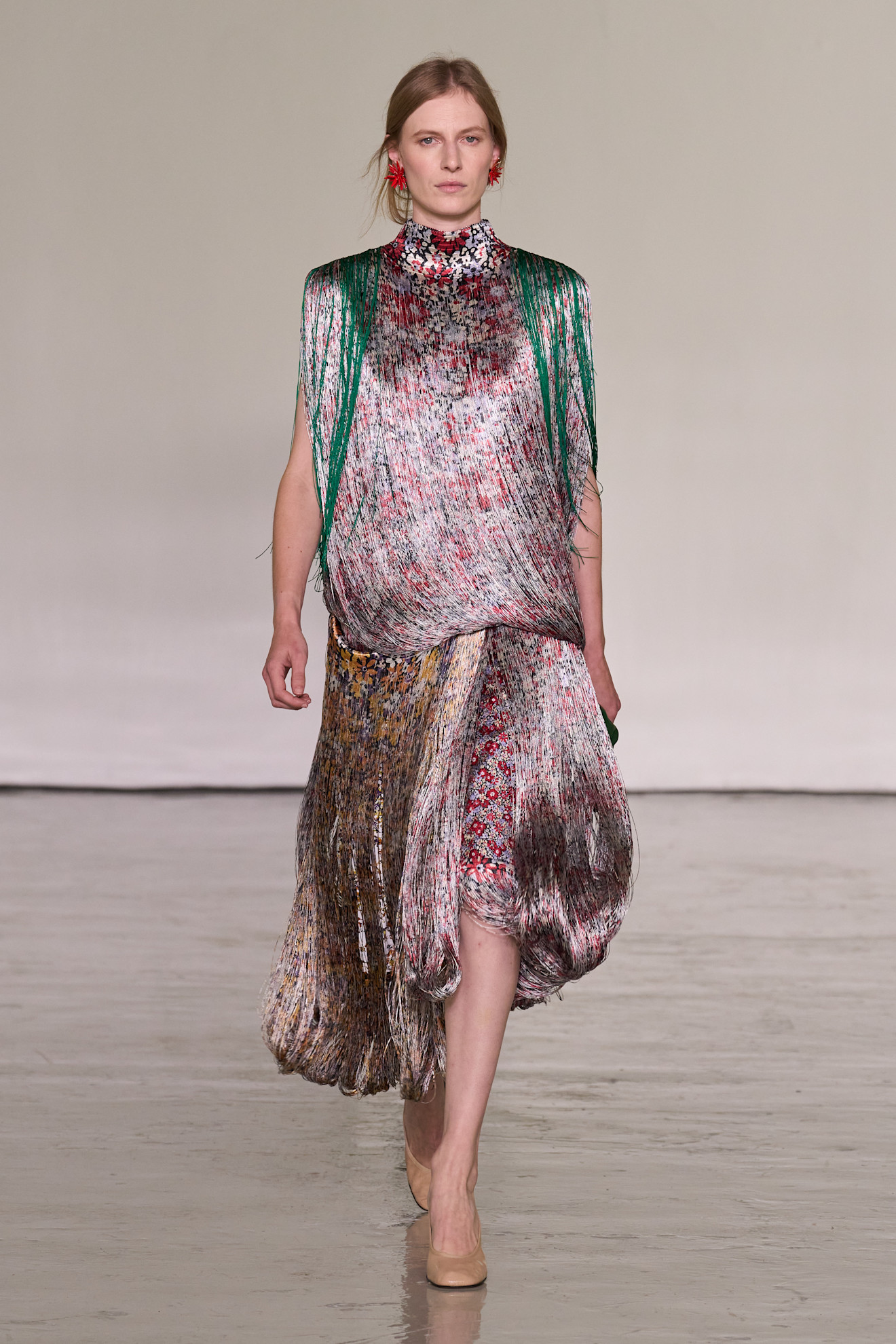 A model walking in the spring/summer 2027 Bottega Veneta show during Milan Fashion Week wearing a fringe dress.